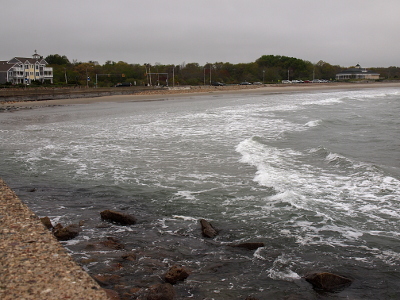 [Multiple shallow waves approaching the sandy shore on the left.]